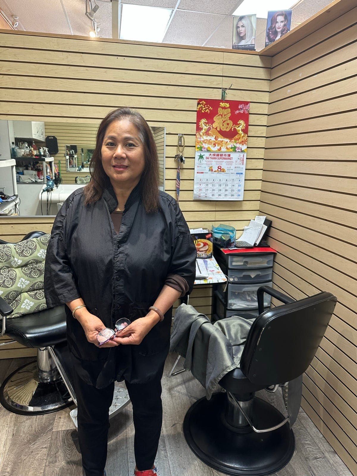 Kim, owner of Hair 7, standing between the styling chairs in her Mountain View salon.